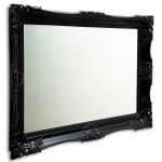 An imposing mirror with a real wooden black swept frame, with intricate detailing and bevelled edged glass mirror.