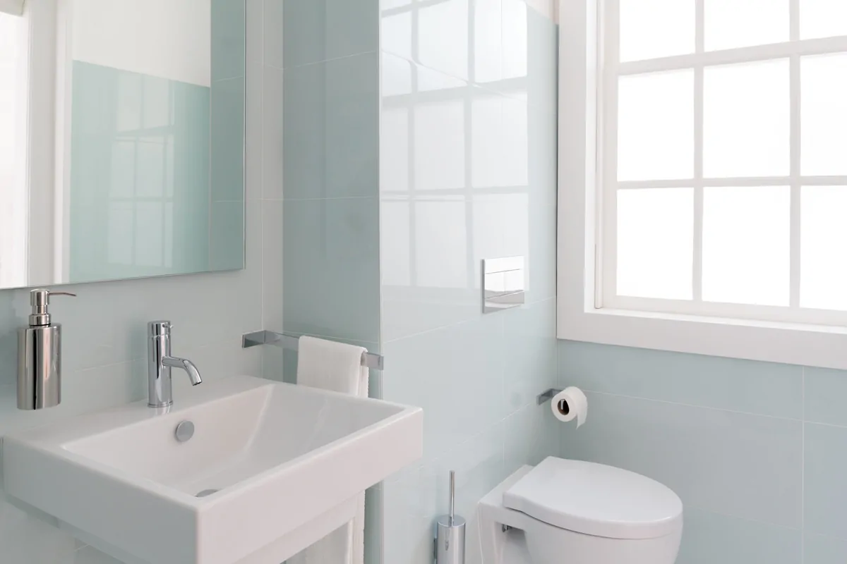 Clean frameless plain glass mirror in a neutral bathroom