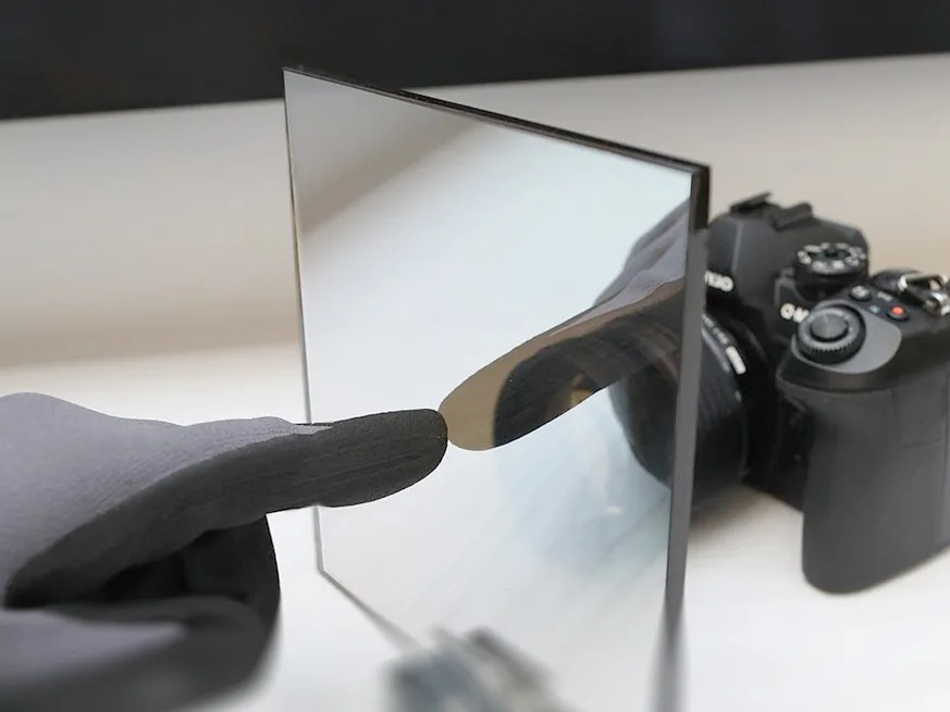 Specialist partially reflective two-way glass beside a camera