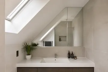 Bathroom mirror fitted neatly below a sloping ceiling