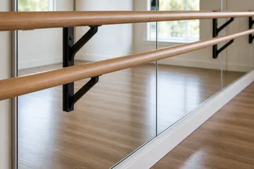 Close view of studio mirrors and ballet barre brackets